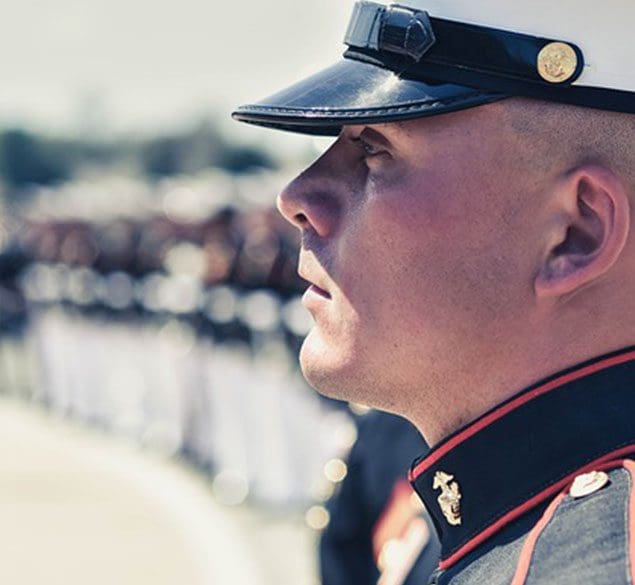 A man in uniform is looking up at something.