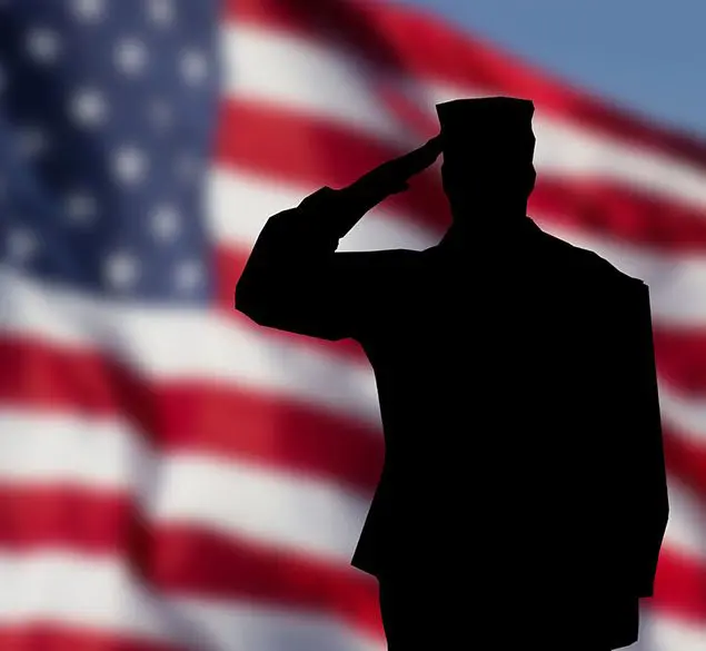 A soldier saluting in front of an american flag.